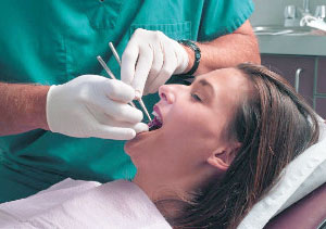A woman lies relaxed in a dentist chair during treatment.