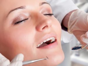 A woman in a relaxed state receiving treatment at the dentist, as though under conscious sedation.