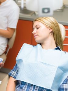 Woman resting in a dental chair from dental sedation